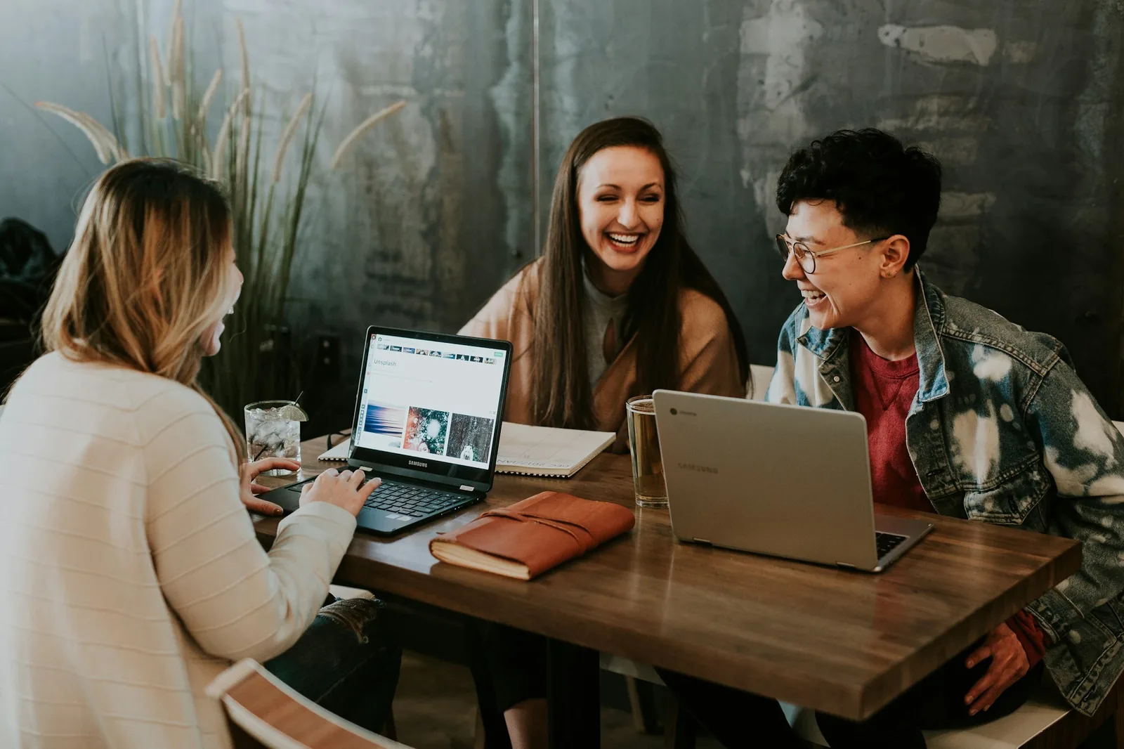 Three colleagues working together at a laptop